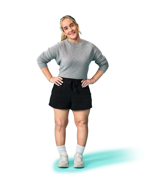 Karabeth, a young woman living with XLH, standing confidently with her hands on her hips and smiling